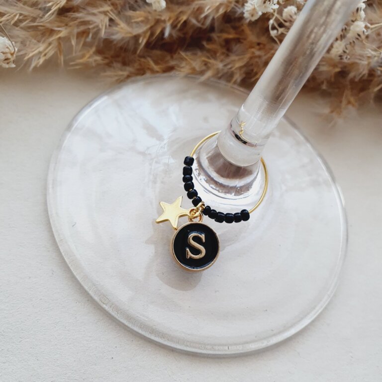 Zwarte kralen en letter aan je wijnglasring.